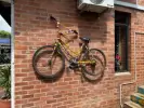 A bright yellow bicycle mounted on a wall at the Hillcrest AIDS Centre Trust.