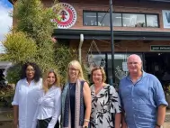 The Shu Powders Africa management team standing outside the entrance of Hillcrest AIDS Centre Trust in Hillcrest, KwaZulu-Natal.
